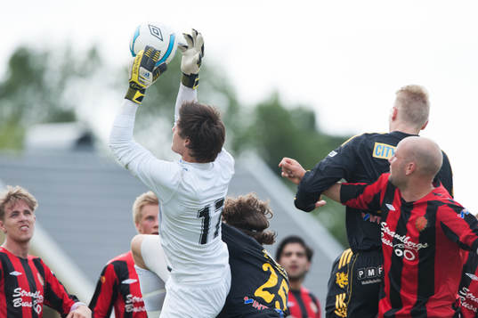 Målvakt greppar bollen, gruppspel framför mål