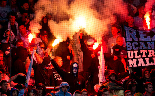 några maskerade personer tände en bengalisk eld