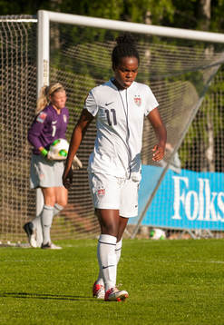 Kayla Mills, USA. Bakom står Jane Campbell, målvakt, USA