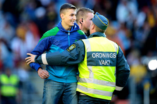 En åskådare stoppas av en ordningsvakt