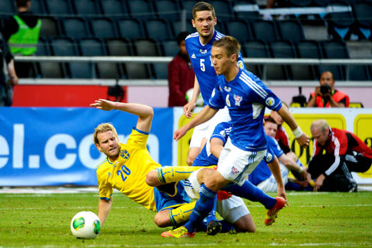 Sveriges Ola Toivonen faller i kamp om bollen i matchen