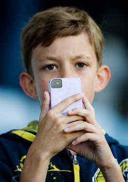 En pojke fotar med sin iPhone