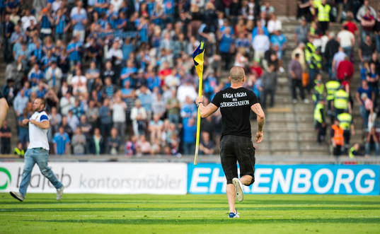 En supporter springer in och tar en hörnsflagga