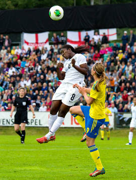 Englands Anita Asante nickar bollen framför Sveriges
