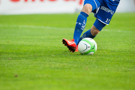 Fot, fotboll, gräs, fotbollsskor i