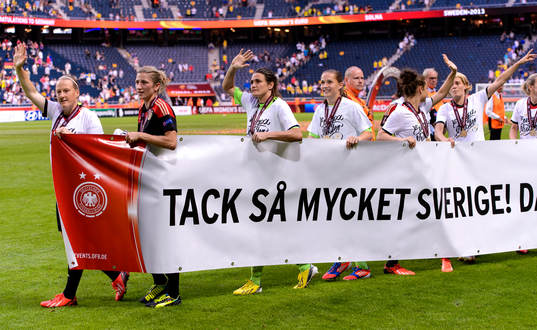 Det tyska laget bär runt en banderoll på arenan med