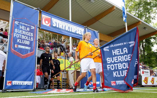 Intåg med Svenska spels fanor i fotbollsmatchen mellan