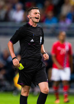 Domare Michael Oliver delar ut ett gult kort
