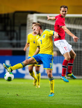 Sveriges Sebastian Larsson i en närkamp med Norges Magnus