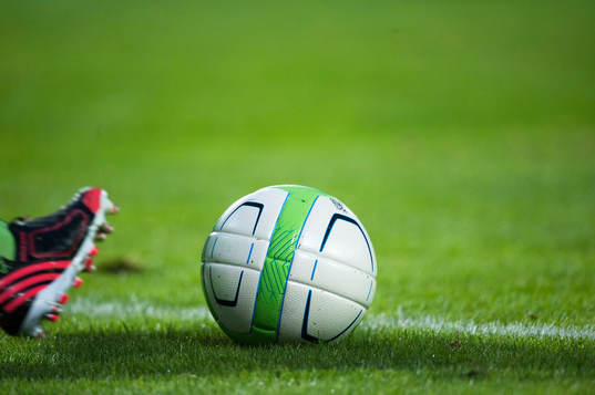 Inspark, fotbollsskor, dubbar, boll, gräs i