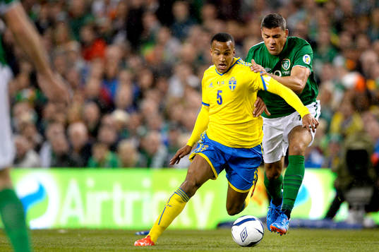 Sveriges Martin Olsson jagas av Irlands Robbie Keane i