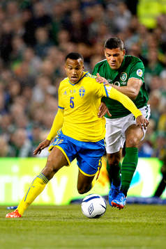 Sveriges Martin Olsson jagas av Irlands Robbie Keane i