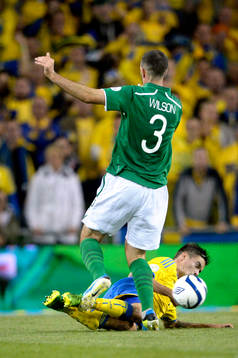 Sveriges Mikael Lustig glidtacklas av Irlands Marc Wilson i