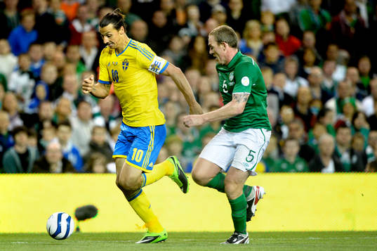 Sveriges Zlatan Ibrahimovic jagas av Irlands Richard Dunne