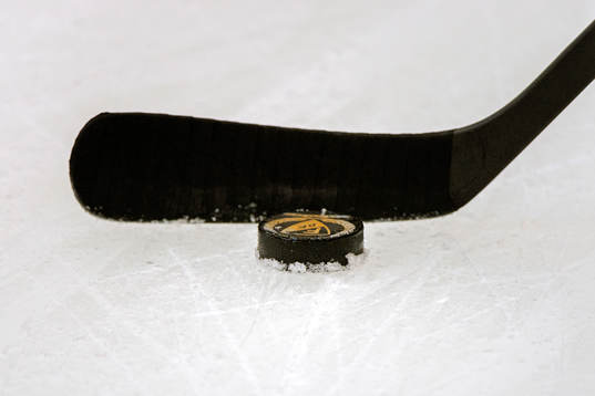 Ishockeyklubba med puck på isen
