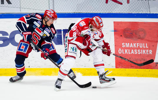 Timrås Per Hallin i kamp om pucken med Södertäljes Jonas