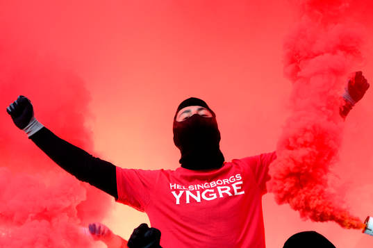 En Helsingborgssupporter syns i ett hav av röd rök
