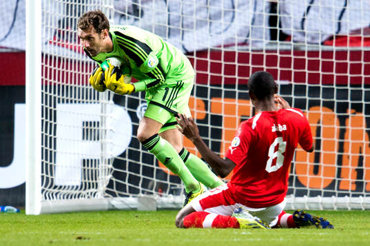 Sveriges målvakt Andreas Isaksson snor bollen framför