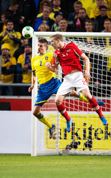 Sveriges Mikael Lustig i en luftduell med Österrikes Marc