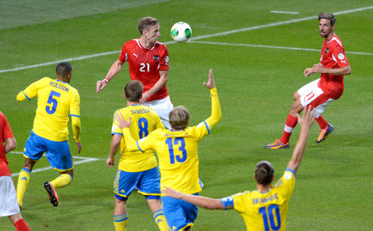 Svenska spelare vinkar för offside när Österrikes Martin