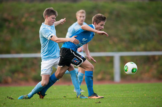En Malmö-spelare tacklar en Halmstads-spelare i SM-finalen