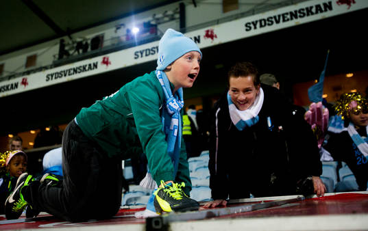 En ung Malmö supporter kryper uppe på spelarbänkens tak