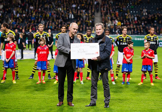 Svenska Spels Erik Kotschack delar ut en check till AIK