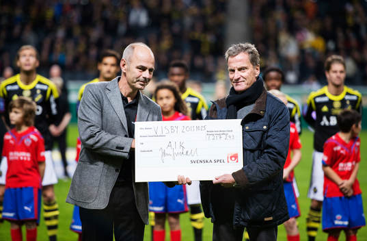 Svenska Spels Erik Kotschack delar ut en check till AIK