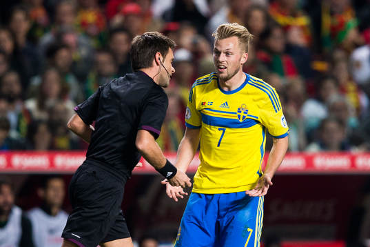 Sveriges Sebastian Larsson talar med domare Nicola Rizzoli