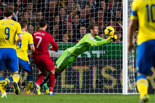 Sveriges målvakt Andreas Isaksson räddar bollen framför
