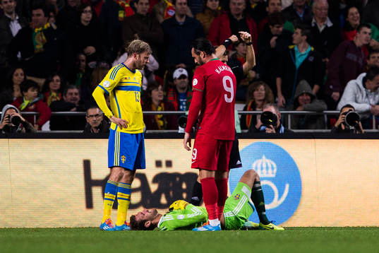 Sveriges målvakt Andreas Isaksson ligger ner