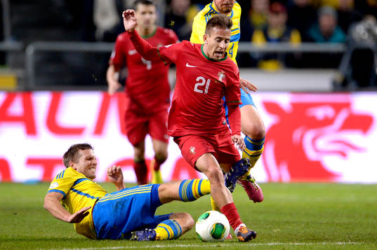 Sveriges Anders Svensson tacklar Portugals Joao Pereira