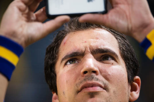 En svensk supporter använder sin mobiltelefon