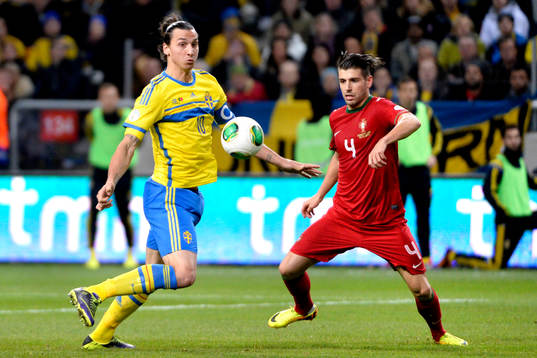 Sveriges Zlatan Ibrahimovic jagar boll framför Portugals