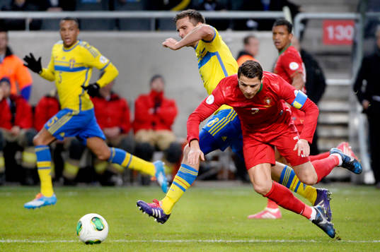 Sveriges Anders Svensson tacklar Portugals Cristiano Ronaldo