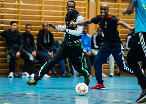 Två killar skrattar i kamp om bollen
