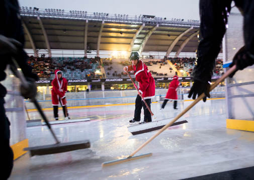 Funktionärer försöker få undan vattnet när matchen