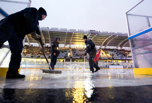 Funktionärer försöker få undan vattnet när matchen