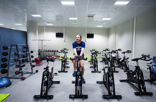 Sveriges Niklas Persson cyklar i ett styrketräningsrum i
