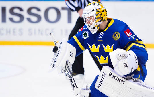 Sveriges målvakt Henrik Karlsson räddar pucken med sin