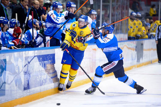 Sveriges Tom Wandell blir tacklad av Finlands Topi Jaakola