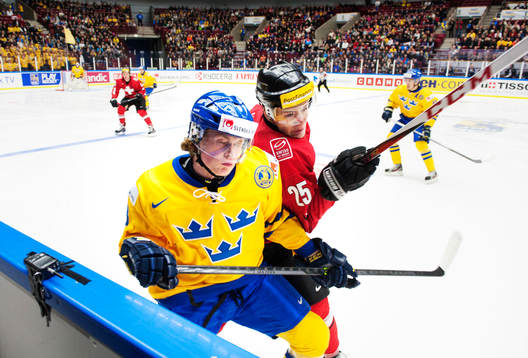 Sveriges Erik Karlsson blir tacklad av Schweiz Dario Simion