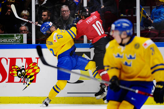 Sveriges Anton Karlsson tacklar Schweiz Vincent Praplan