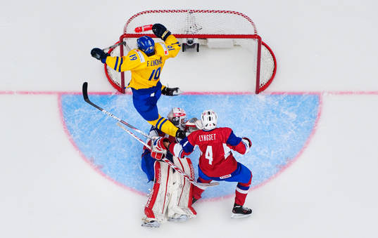 Sveriges Elias Lindholm flyger över Norges målvakt Henrik