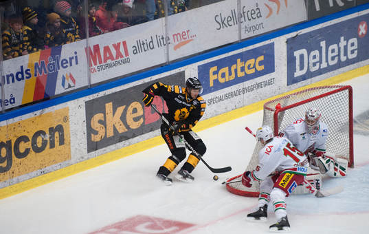 Skellefteås Erik Forsell med pucken bakom målburen, jagad