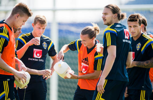 Niklas Hult langar vatten åt spelarna Pontus Jansson, Emil