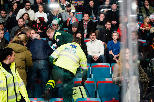 kvinna i publiken träffas illa av en puck och får föras