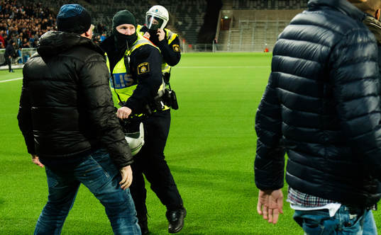 Polisen försöker hindra supportrar att springa in på