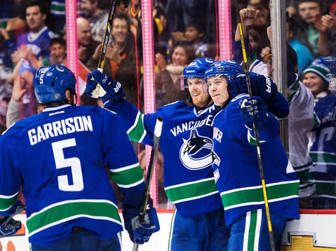 Vancouvers Jason Garrison, Daniel Sedin och Zac Dalpe jublar