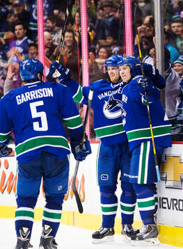 Vancouvers Jason Garrison, Daniel Sedin och Zac Dalpe jublar